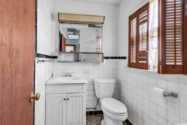 bathroom with vanity, tile walls, and toilet