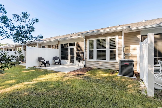 rear view of property featuring a yard, central AC, and a patio area