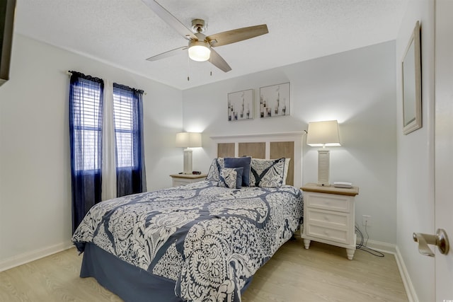 bedroom with ceiling fan, light hardwood / wood-style flooring, and a textured ceiling