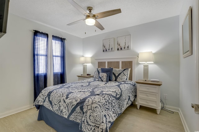 bedroom featuring ceiling fan, a textured ceiling, and light wood-type flooring