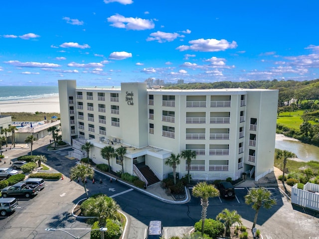 view of building exterior with a water view and a view of the beach