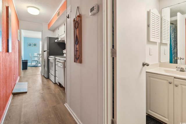 hall with sink, a textured ceiling, and dark hardwood / wood-style flooring