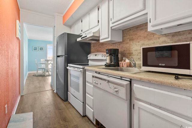 kitchen featuring tasteful backsplash, sink, white appliances, and white cabinets