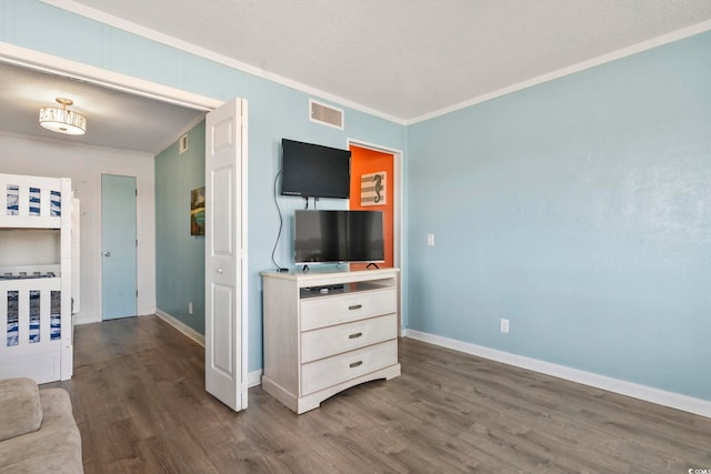 bedroom featuring ornamental molding, a textured ceiling, and dark hardwood / wood-style flooring