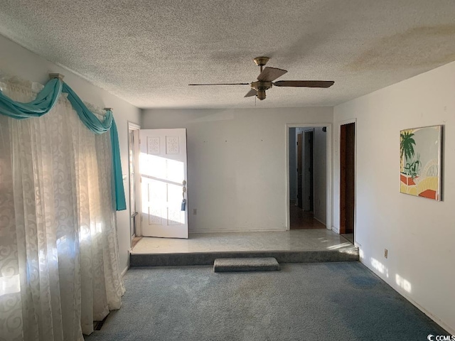 unfurnished room with ceiling fan, light colored carpet, and a textured ceiling