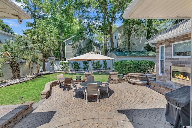 view of patio / terrace with a grill and an outdoor stone fireplace