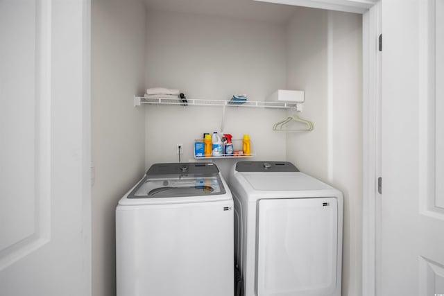 clothes washing area featuring laundry area and washing machine and clothes dryer