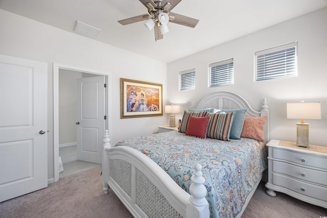 bedroom featuring a ceiling fan, light colored carpet, visible vents, and baseboards