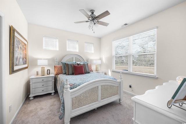 bedroom with light carpet, baseboards, visible vents, and a ceiling fan