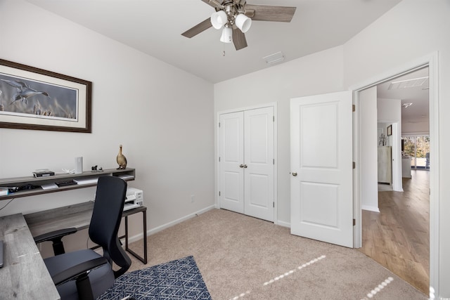 office space with ceiling fan, light carpet, visible vents, and baseboards