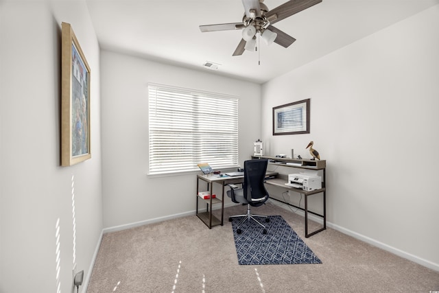 office area with baseboards, visible vents, a ceiling fan, and light colored carpet