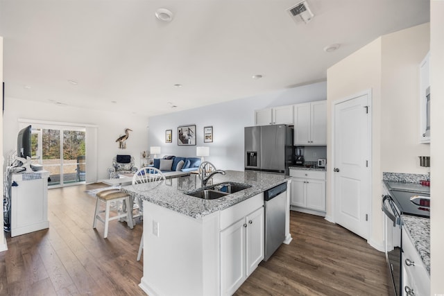 kitchen with white cabinetry, appliances with stainless steel finishes, open floor plan, and a sink