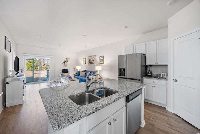 kitchen with a kitchen island with sink, white cabinetry, stainless steel appliances, and a sink