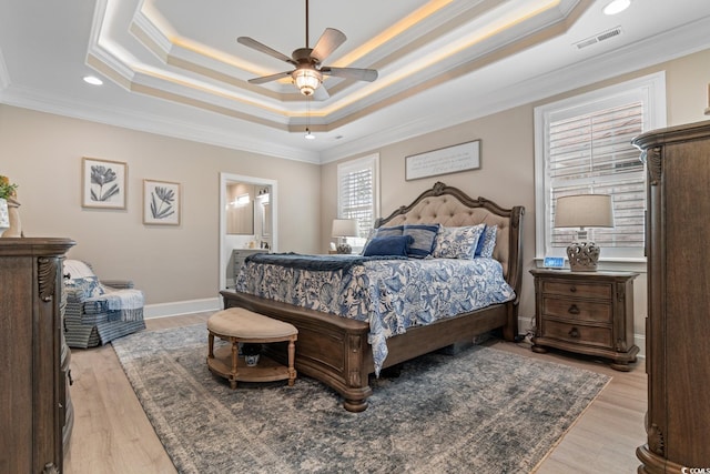 bedroom featuring ornamental molding, a raised ceiling, and light hardwood / wood-style floors