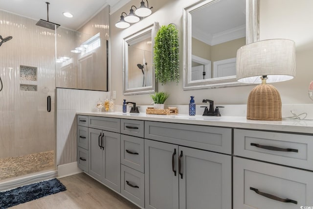 bathroom featuring walk in shower, ornamental molding, vanity, and hardwood / wood-style flooring