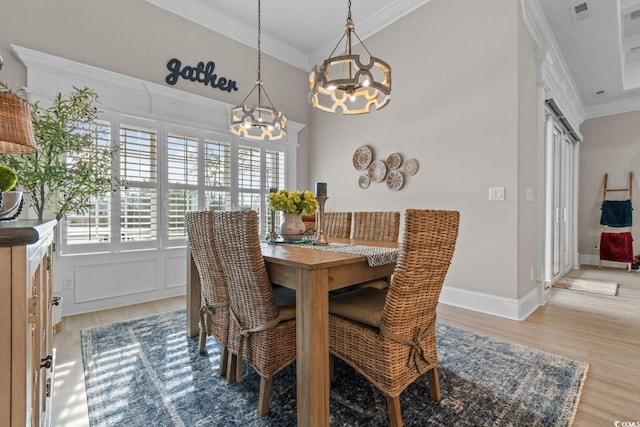 dining space featuring light hardwood / wood-style flooring and ornamental molding