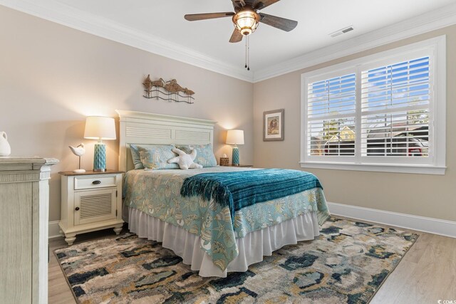 bedroom featuring crown molding, a closet, ceiling fan, and light hardwood / wood-style flooring