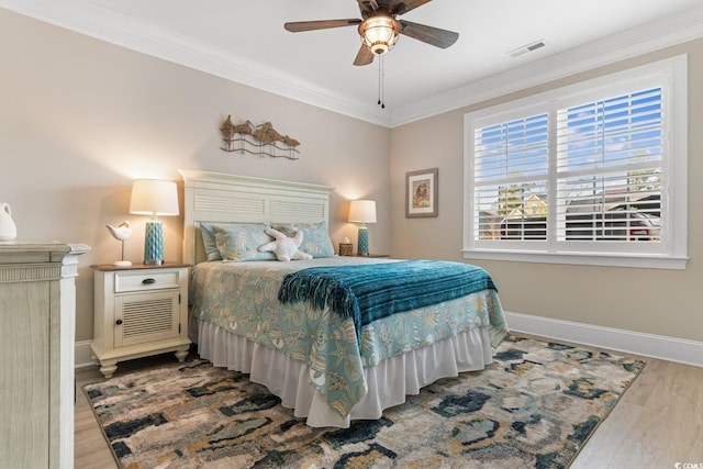 bedroom featuring wood-type flooring, ornamental molding, and ceiling fan