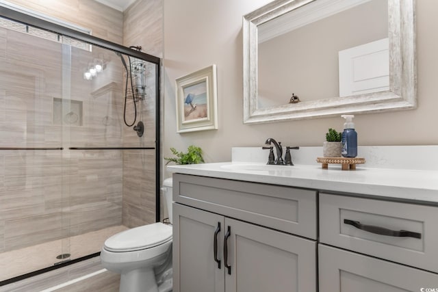 bathroom with a shower with door, vanity, and toilet