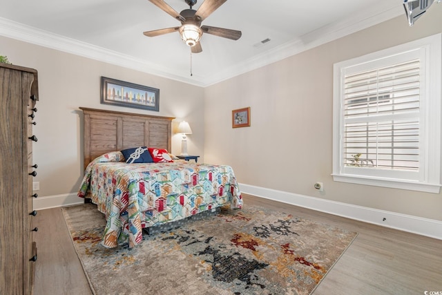 bedroom featuring hardwood / wood-style flooring, ceiling fan, and crown molding