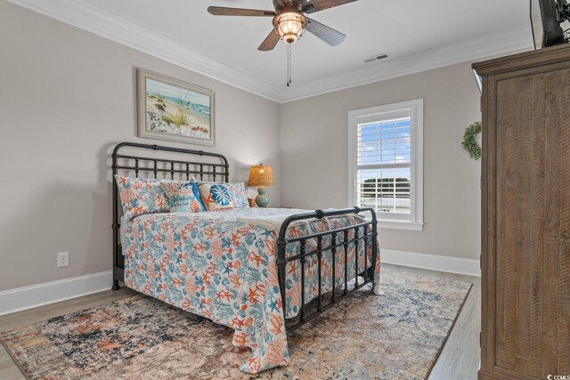 bedroom featuring crown molding, ceiling fan, hardwood / wood-style floors, and a closet