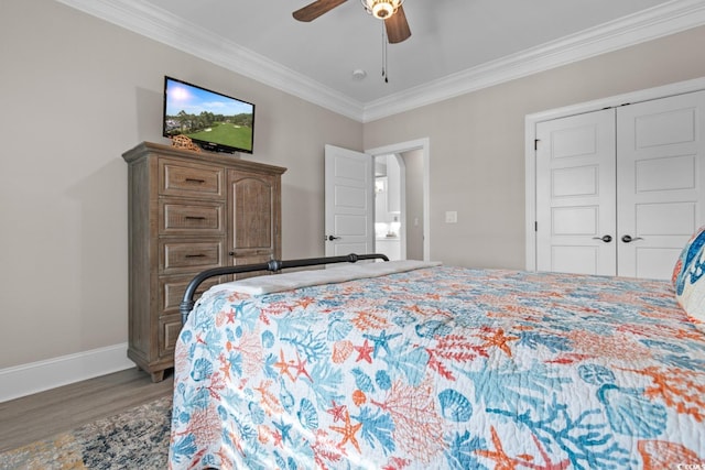 bedroom featuring crown molding, ceiling fan, wood-type flooring, and a closet