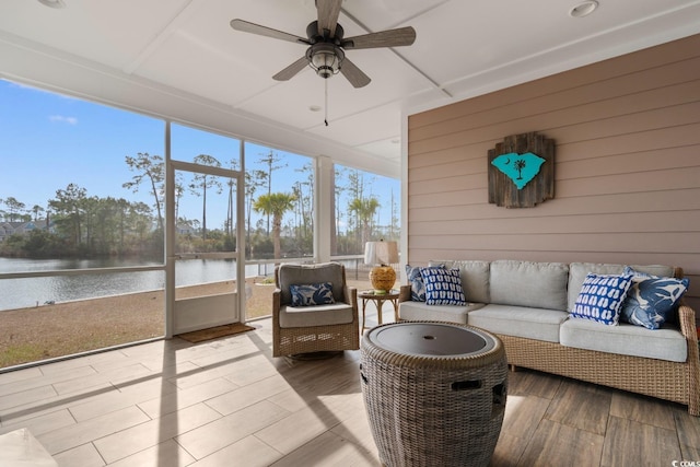 sunroom / solarium featuring ceiling fan and a water view