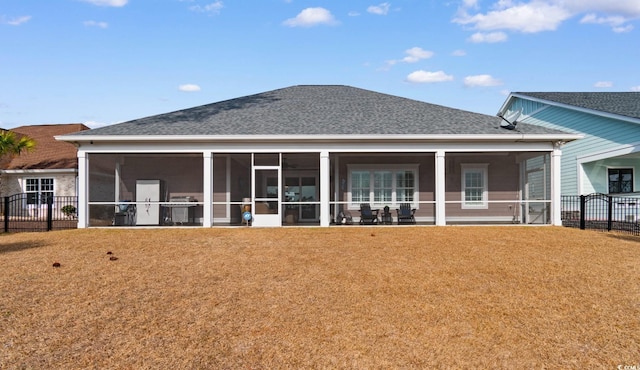 rear view of property with a sunroom and a lawn