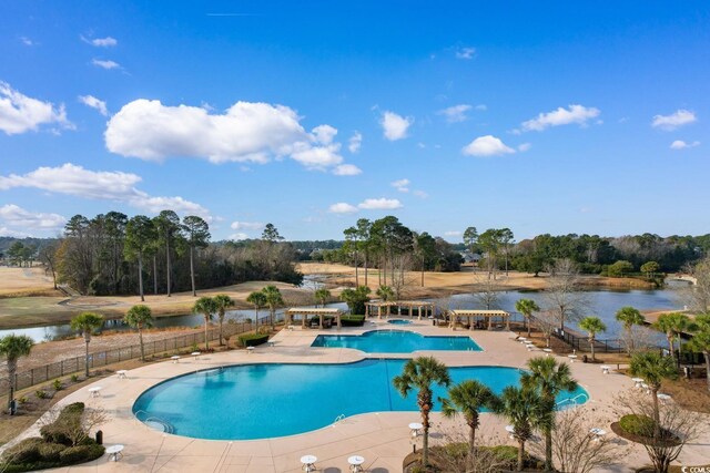 view of swimming pool featuring a water view and a patio