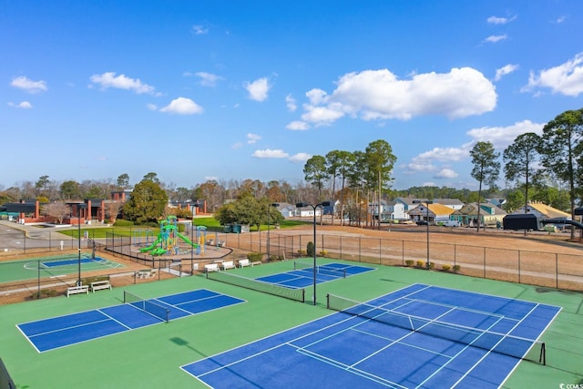 view of tennis court featuring basketball hoop and a playground