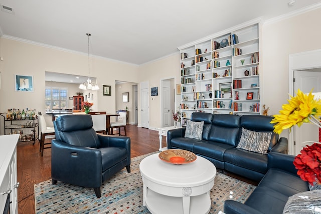 living room with wood-type flooring, ornamental molding, and an inviting chandelier