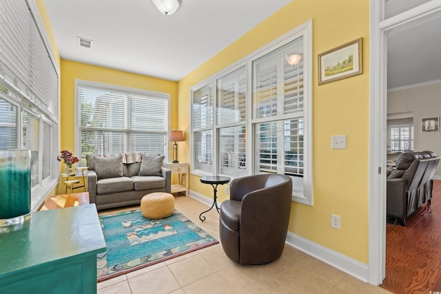 living area featuring ornamental molding, plenty of natural light, and light tile patterned floors