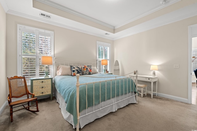 carpeted bedroom featuring ornamental molding and a tray ceiling