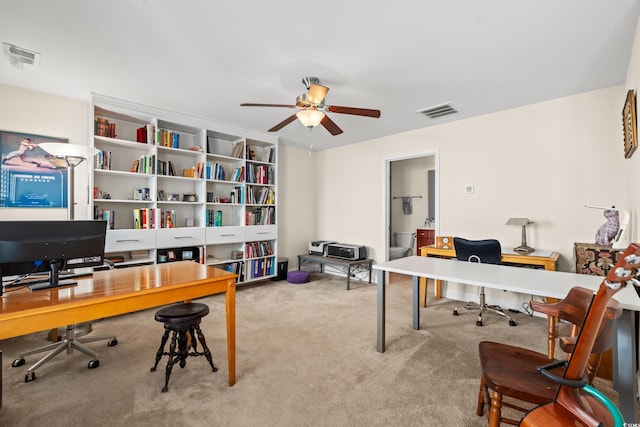 carpeted home office featuring ceiling fan