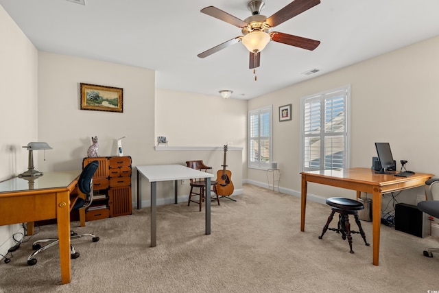 carpeted office space featuring ceiling fan