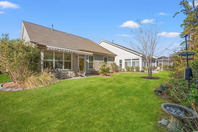 rear view of property with a yard and a patio