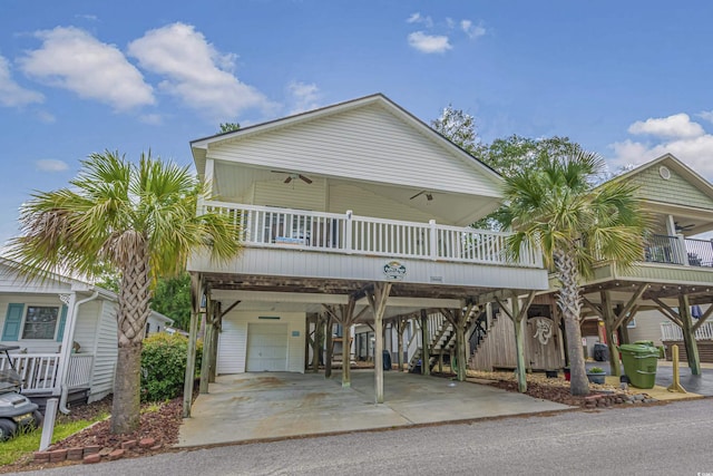 raised beach house featuring a carport, ceiling fan, and covered porch