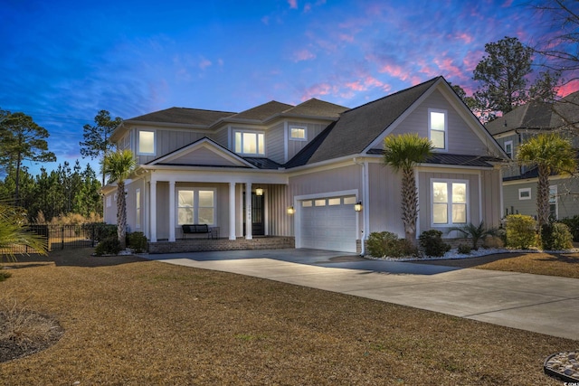 view of front facade featuring a porch, a garage, and a lawn