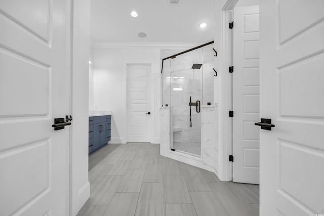 bathroom with an enclosed shower, ornamental molding, and vanity