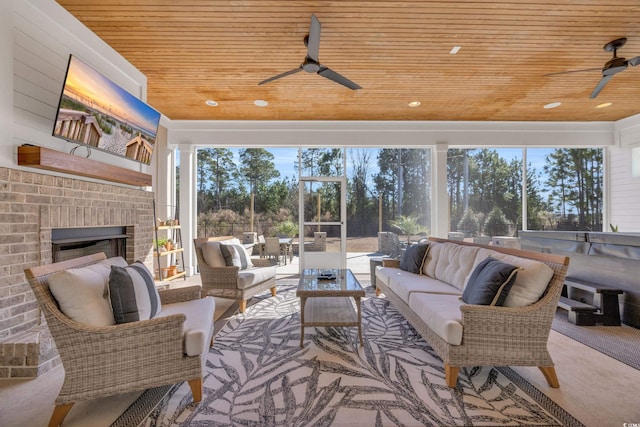 sunroom featuring an outdoor brick fireplace, ceiling fan, and wood ceiling