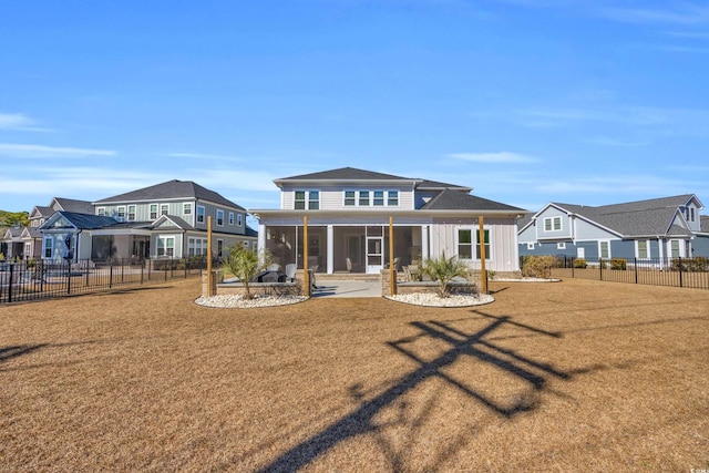 back of house with a lawn, a sunroom, and a patio area