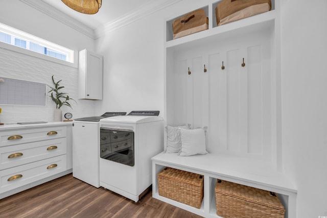 washroom with cabinets, crown molding, dark hardwood / wood-style floors, and washing machine and clothes dryer