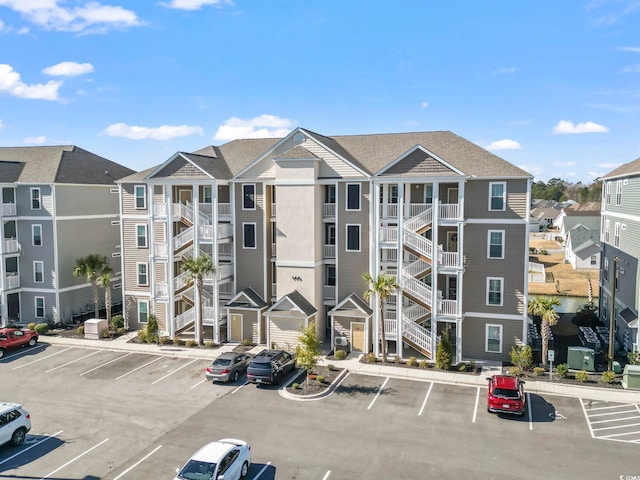 view of building exterior with uncovered parking and a residential view