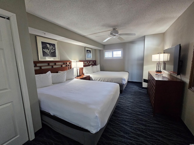 carpeted bedroom featuring ceiling fan and a textured ceiling