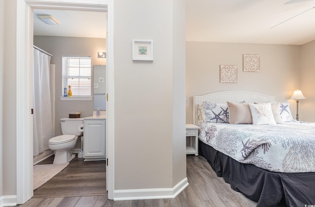 bedroom with wood-type flooring and connected bathroom