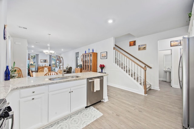 kitchen with stainless steel appliances, a sink, and white cabinetry