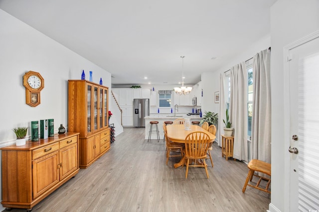 dining space featuring a chandelier, stairway, light wood-style flooring, and recessed lighting