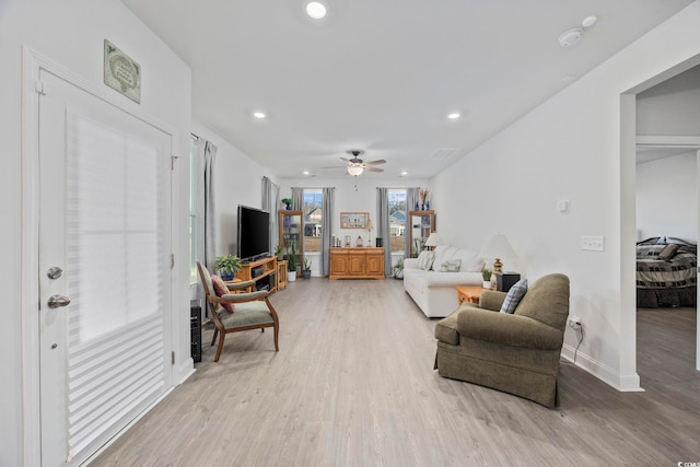 living room featuring light wood-type flooring, baseboards, a ceiling fan, and recessed lighting