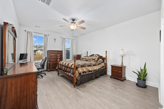 bedroom with light wood finished floors, baseboards, visible vents, and ceiling fan