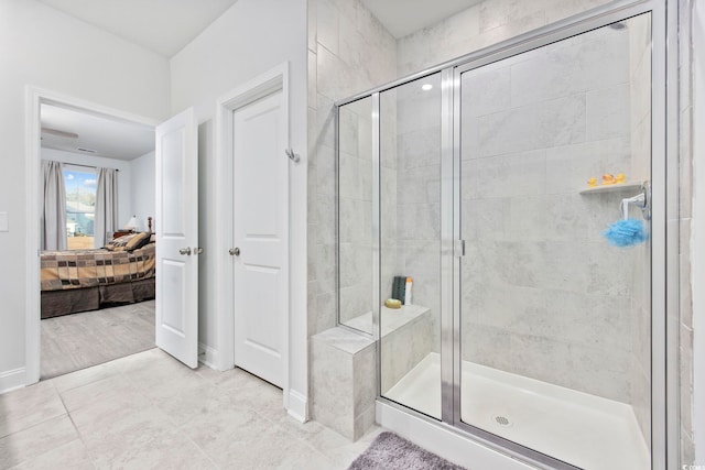 ensuite bathroom featuring a stall shower, tile patterned flooring, ensuite bath, and baseboards